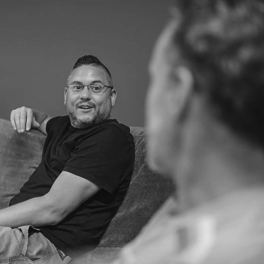 James Guest in conversation, sitting on a sofa